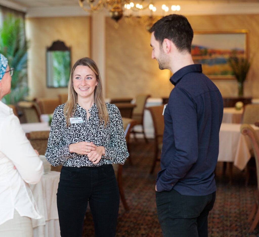 2 women and a man standing talking to each other