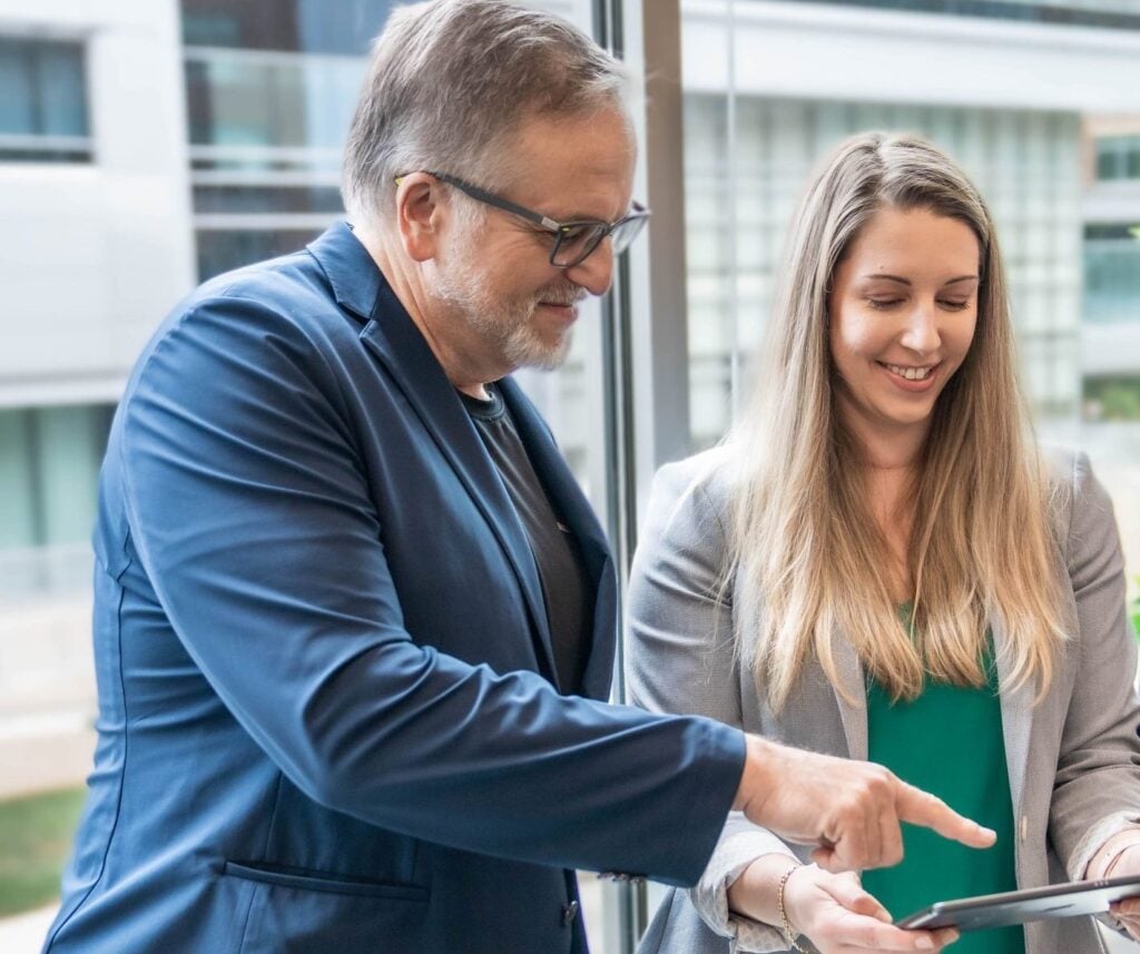 A man and woman looking at an iPad