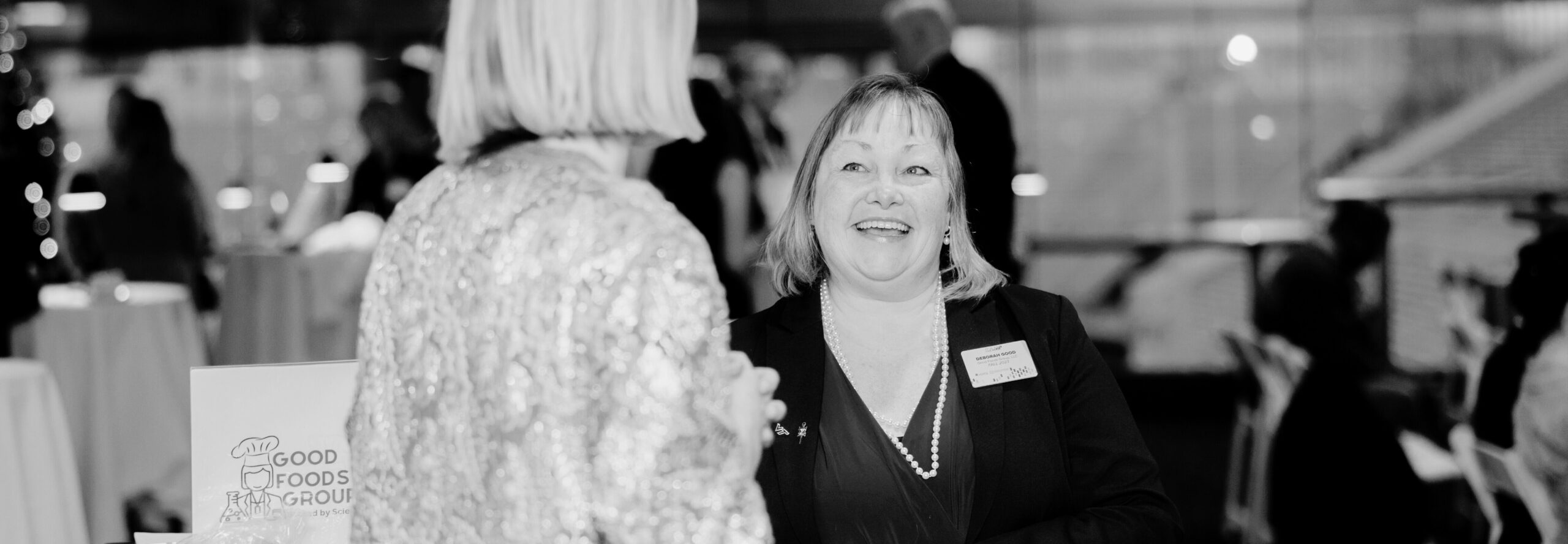 Black and white photo of 2 women talking