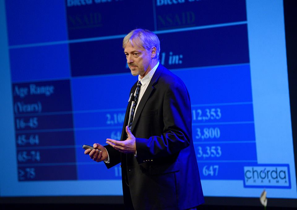 A man standing on stage giving a presentation